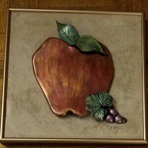 framed metallic apple art on tile